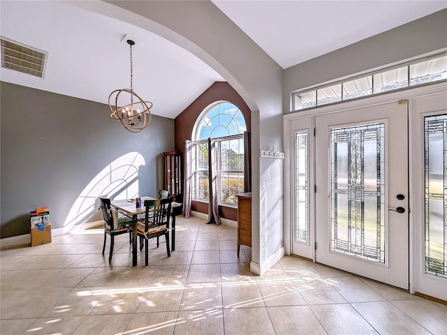 entrance foyer featuring an inviting chandelier, lofted ceiling, and light tile patterned floors