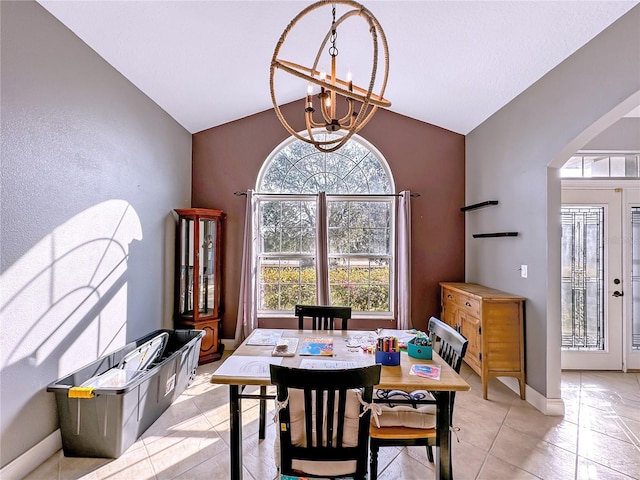 tiled dining room with vaulted ceiling and a notable chandelier