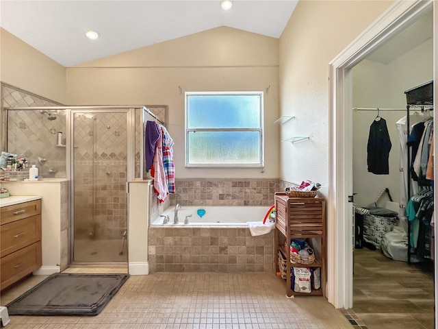 bathroom with lofted ceiling, separate shower and tub, tile patterned flooring, and vanity