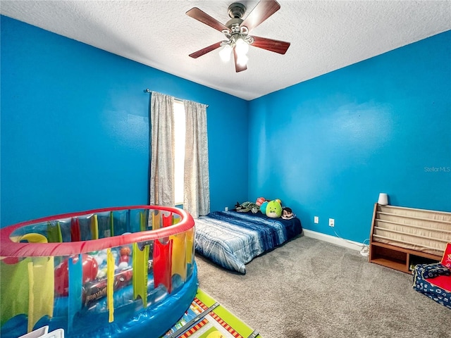 bedroom with ceiling fan, carpet, and a textured ceiling