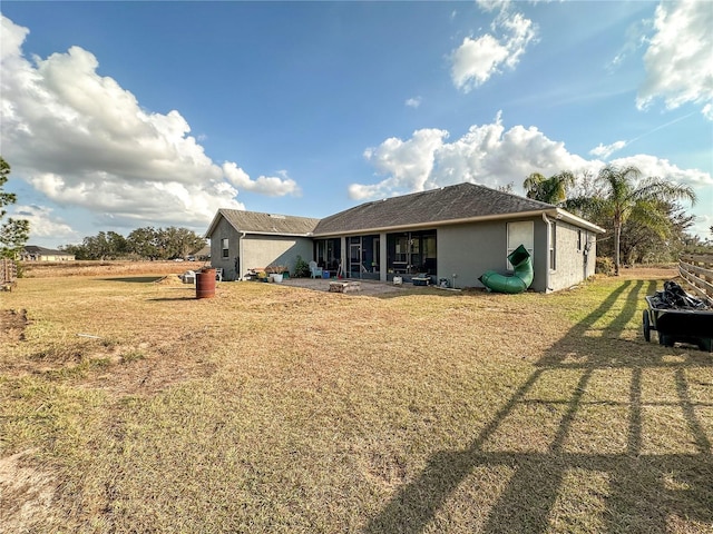 back of property with a yard and a patio