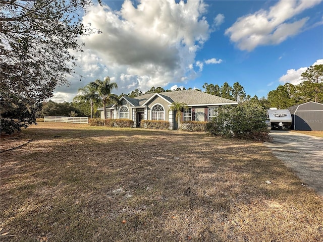 single story home featuring a front lawn