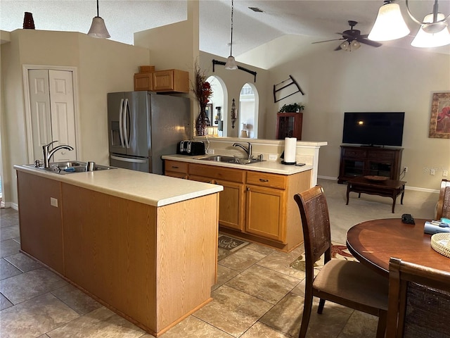 kitchen featuring stainless steel fridge with ice dispenser, sink, a kitchen island with sink, and decorative light fixtures