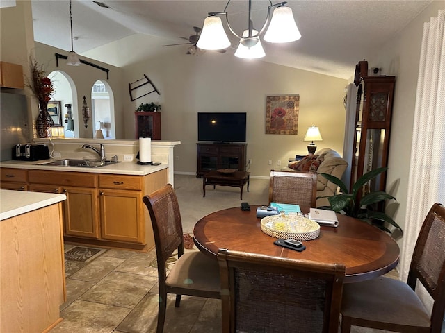 dining space featuring lofted ceiling, sink, and ceiling fan