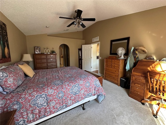 bedroom with lofted ceiling, a textured ceiling, light colored carpet, and ceiling fan