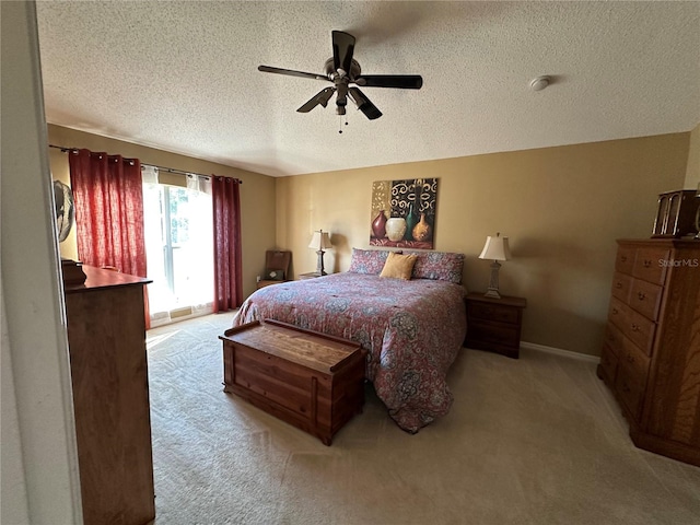 bedroom with ceiling fan, light carpet, and a textured ceiling