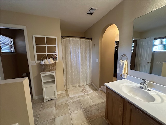 bathroom featuring vanity, tile patterned flooring, and walk in shower