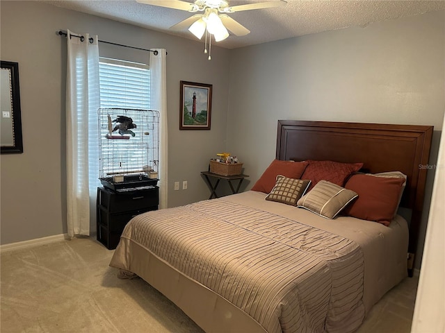 bedroom featuring ceiling fan, light colored carpet, and a textured ceiling