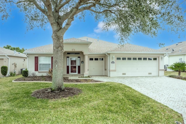 ranch-style home with cooling unit, a garage, and a front yard