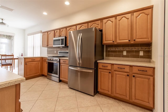 kitchen featuring tasteful backsplash, light tile patterned flooring, and appliances with stainless steel finishes