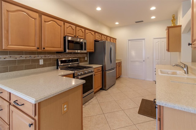 kitchen featuring sink, decorative backsplash, light tile patterned floors, and appliances with stainless steel finishes