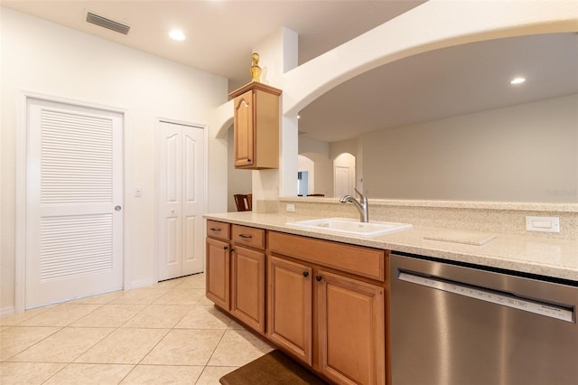 kitchen with light stone counters, sink, stainless steel dishwasher, and light tile patterned flooring