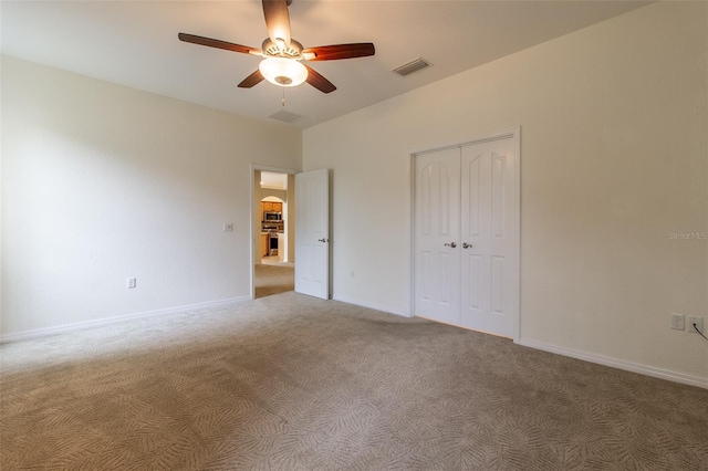 unfurnished bedroom featuring carpet floors, a closet, and ceiling fan