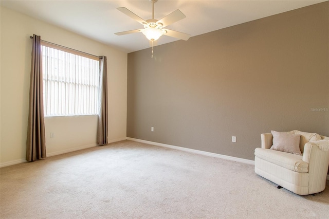 living area with light carpet and ceiling fan