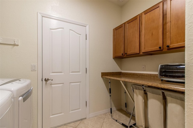 laundry area featuring cabinets, washing machine and dryer, and light tile patterned floors