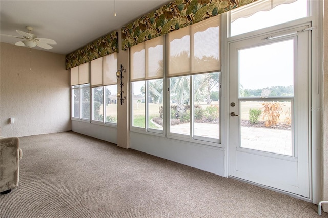 unfurnished sunroom with ceiling fan