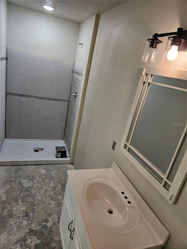 bathroom featuring vanity, concrete floors, a textured ceiling, and walk in shower