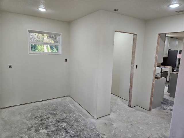 spare room with a textured ceiling