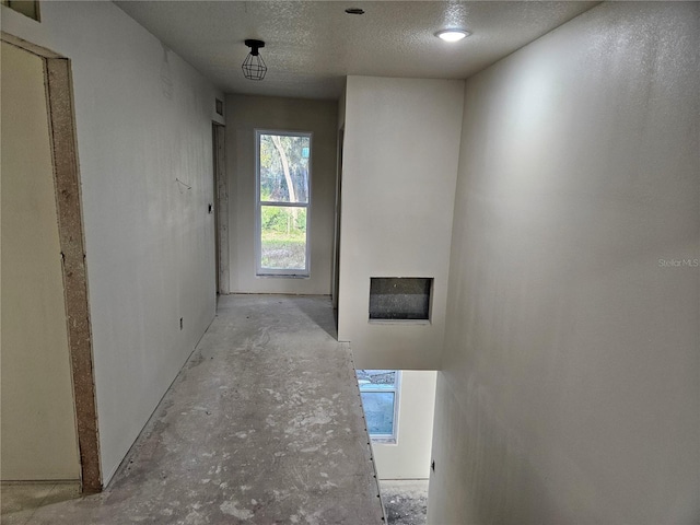 hallway with a textured ceiling