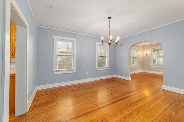 unfurnished room featuring crown molding, an inviting chandelier, and light hardwood / wood-style flooring