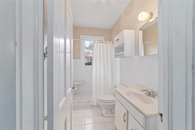 bathroom with toilet, a shower with curtain, tile walls, vanity, and tile patterned flooring