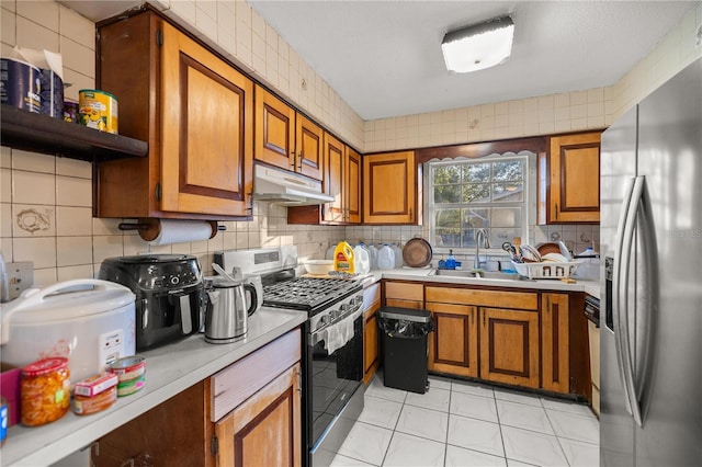 kitchen featuring tasteful backsplash, sink, light tile patterned floors, and stainless steel appliances