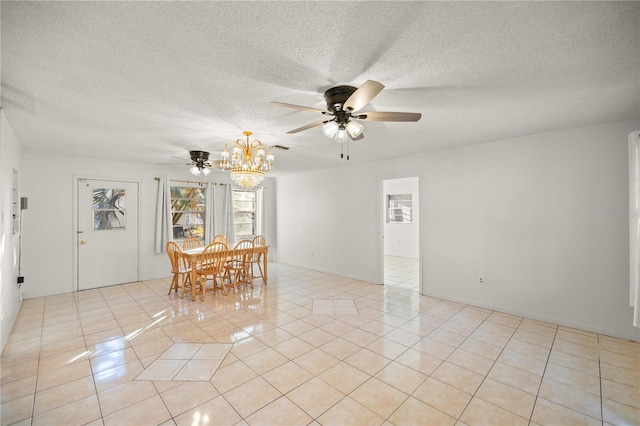 unfurnished dining area with ceiling fan with notable chandelier, a textured ceiling, and light tile patterned flooring