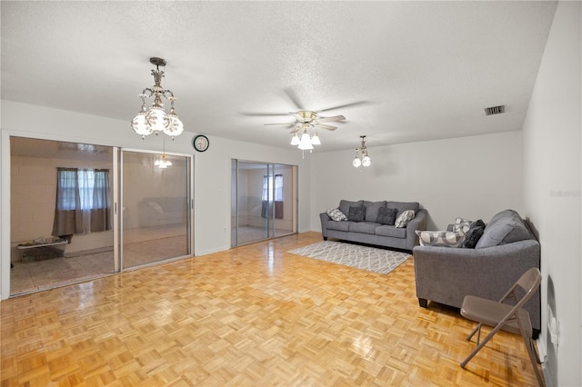 living room featuring light parquet floors, ceiling fan, and a textured ceiling