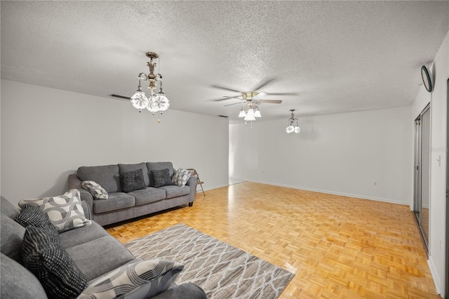 living room featuring parquet floors, ceiling fan, and a textured ceiling