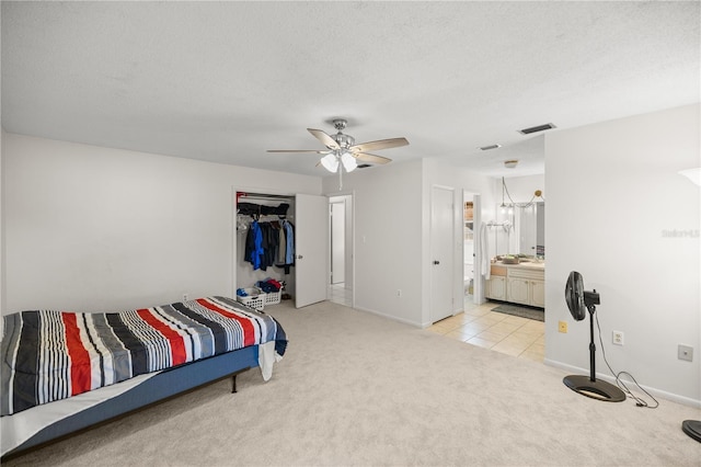 carpeted bedroom with ceiling fan, a closet, and a textured ceiling