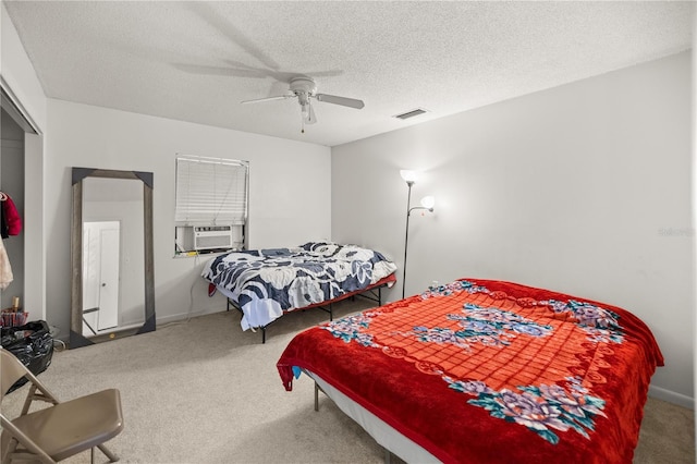 bedroom featuring cooling unit, carpet, ceiling fan, a textured ceiling, and a closet