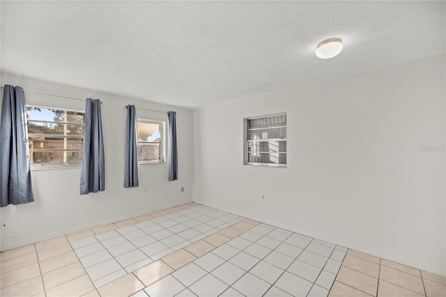 empty room featuring light tile patterned flooring and a textured ceiling