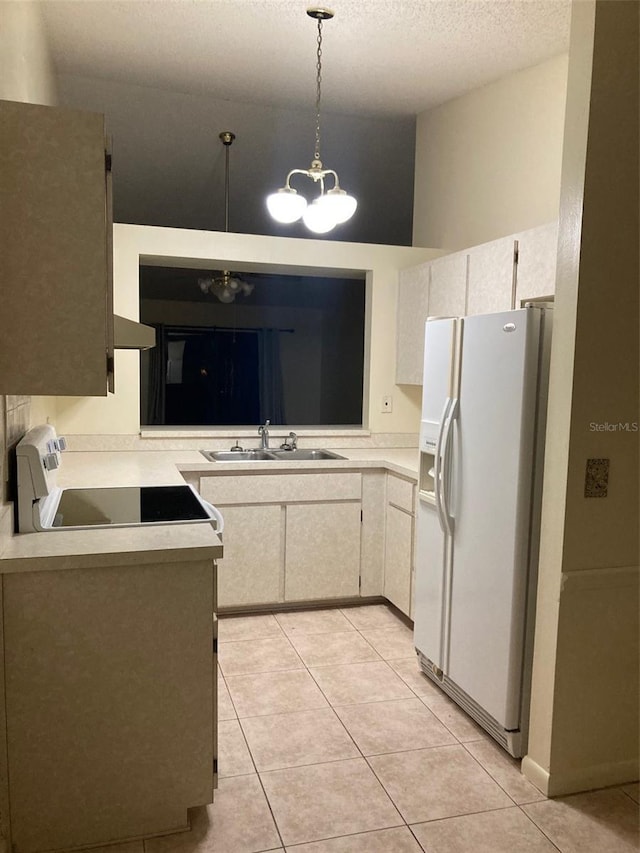 kitchen with light tile patterned flooring, pendant lighting, white fridge with ice dispenser, and sink