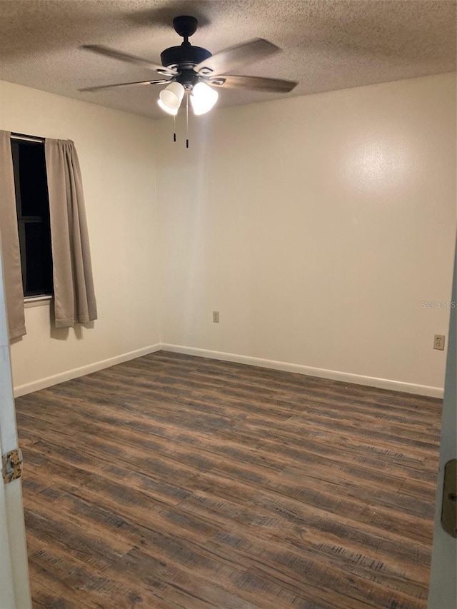 empty room featuring dark hardwood / wood-style flooring, ceiling fan, and a textured ceiling