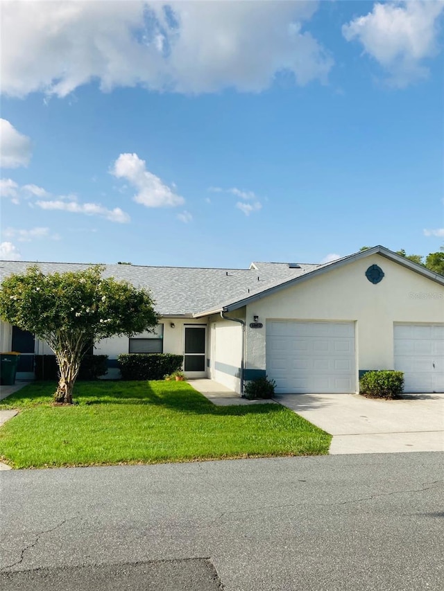 ranch-style home with a garage and a front lawn