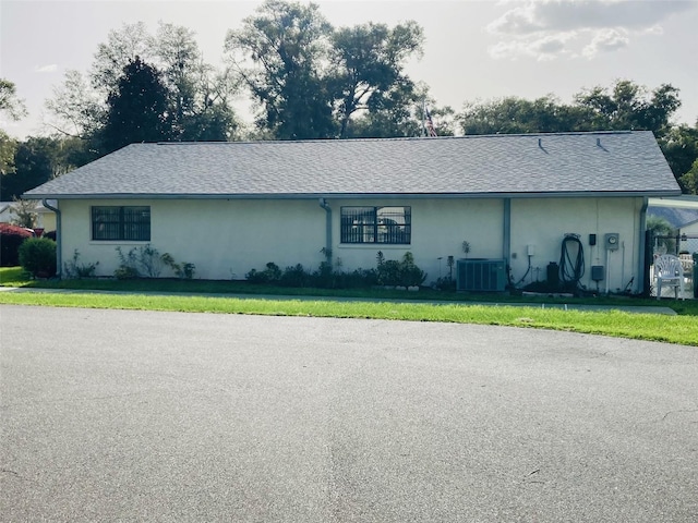 ranch-style house with central AC unit and a front yard