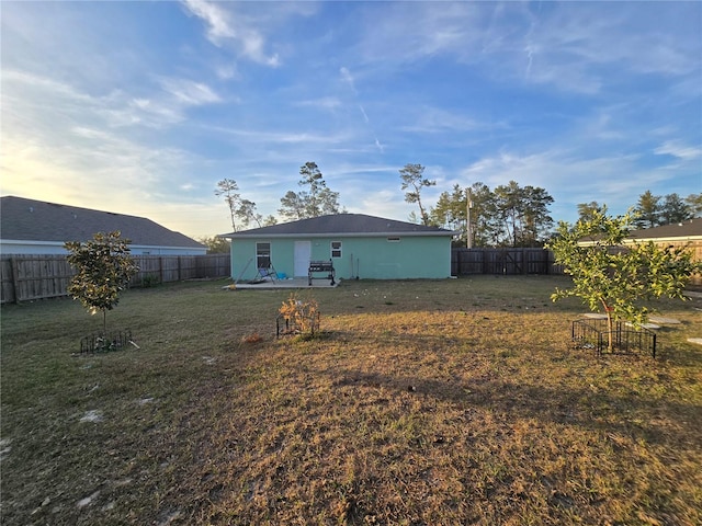 rear view of property with a yard and a patio