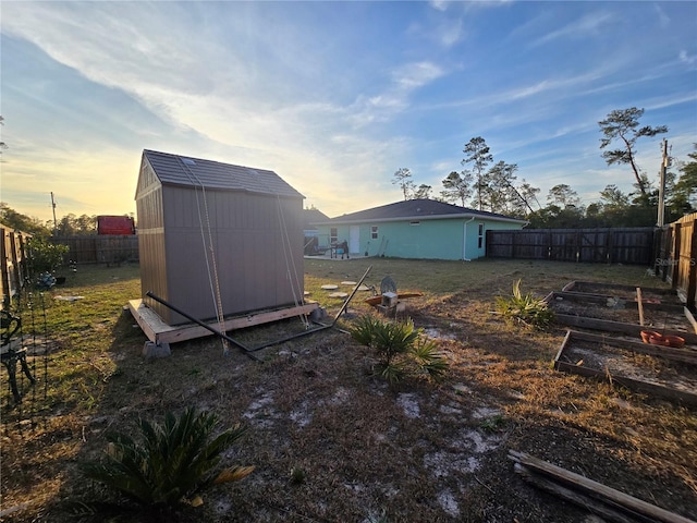 yard at dusk featuring a storage unit