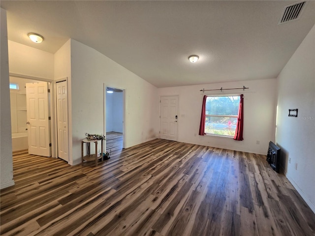 empty room featuring vaulted ceiling and dark hardwood / wood-style floors