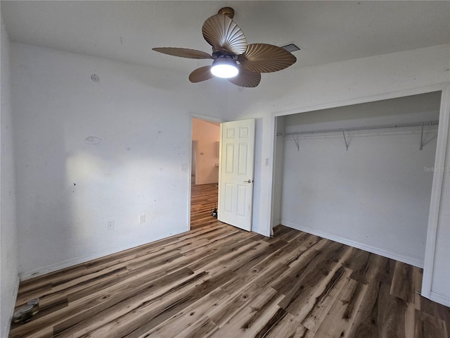 unfurnished bedroom featuring dark hardwood / wood-style floors, ceiling fan, and a closet