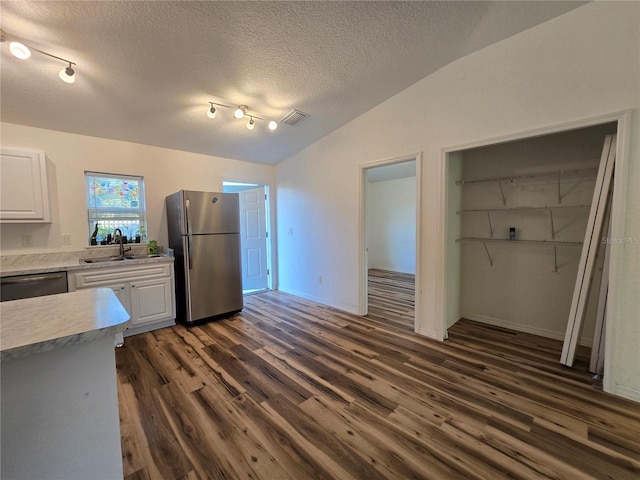 kitchen featuring sink, stainless steel appliances, white cabinets, dark hardwood / wood-style flooring, and vaulted ceiling