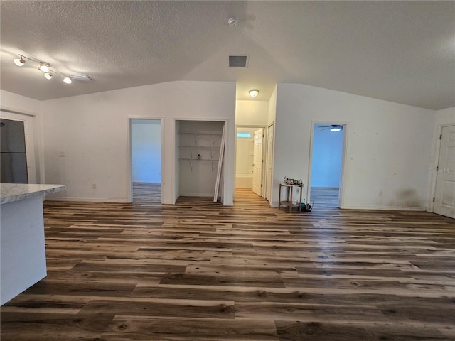 unfurnished living room with lofted ceiling, dark hardwood / wood-style flooring, and a textured ceiling