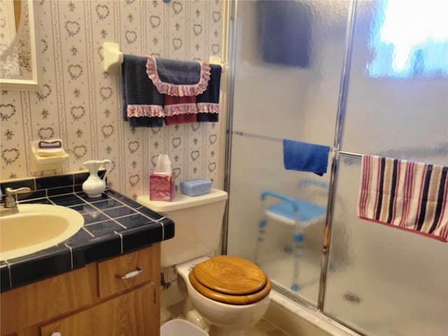 bathroom featuring vanity, an enclosed shower, and toilet