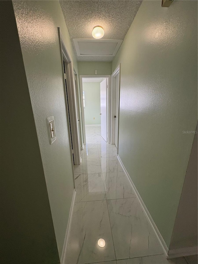 hallway featuring a textured ceiling