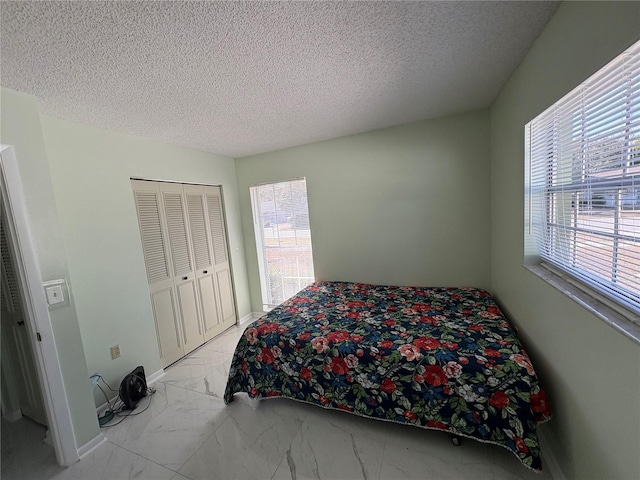 bedroom with a textured ceiling and a closet