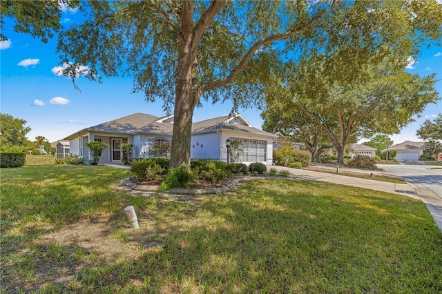 single story home with stucco siding, concrete driveway, a front yard, and a garage