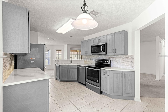 kitchen featuring sink, gray cabinetry, decorative light fixtures, light tile patterned floors, and stainless steel appliances