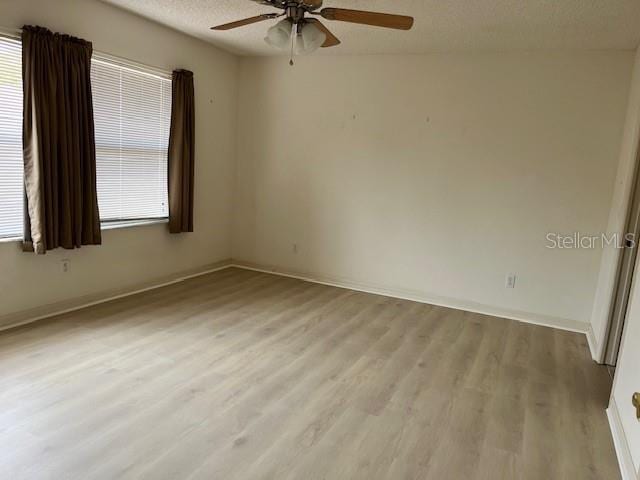 unfurnished room with ceiling fan, light hardwood / wood-style floors, and a textured ceiling