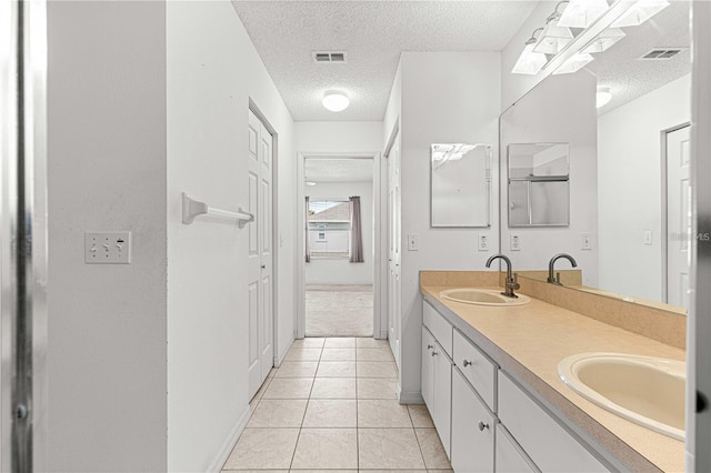 bathroom featuring tile patterned flooring, vanity, and a textured ceiling