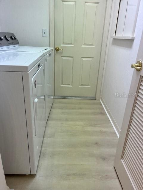 washroom with light hardwood / wood-style floors and independent washer and dryer